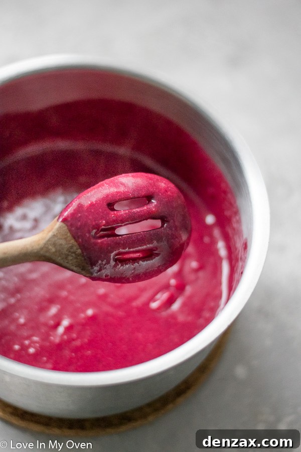 Vibrant Cranberry Curd 4 Cranberry curd thickening on the stove, coating a spoon.
