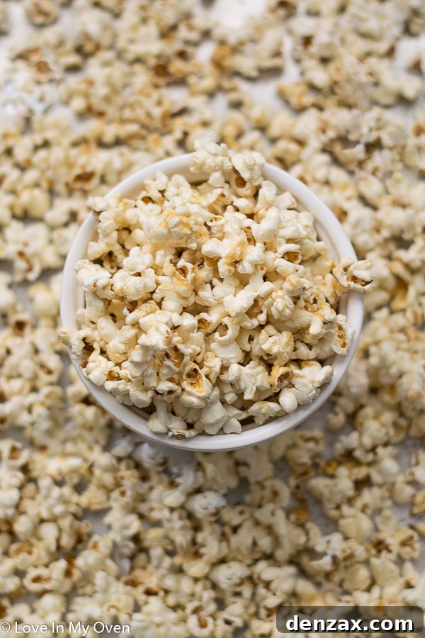 Close-up of golden healthy caramel popcorn spread on a baking sheet, showcasing its perfect crispy texture and inviting shine.