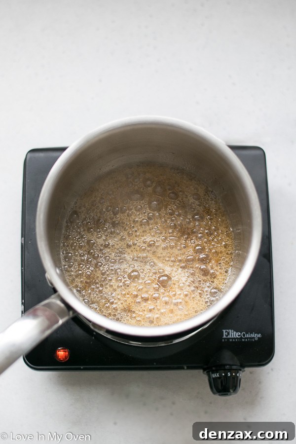Maple syrup and coconut oil bubbling in a saucepan, forming the healthy caramel sauce.