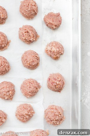 Chilled strawberry cake pop balls on a baking sheet