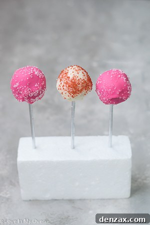 Strawberry cake pops drying on a styrofoam block