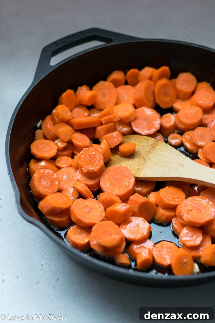 Garlic Butter Roasted Carrots spread on a baking sheet, seasoned with salt and pepper