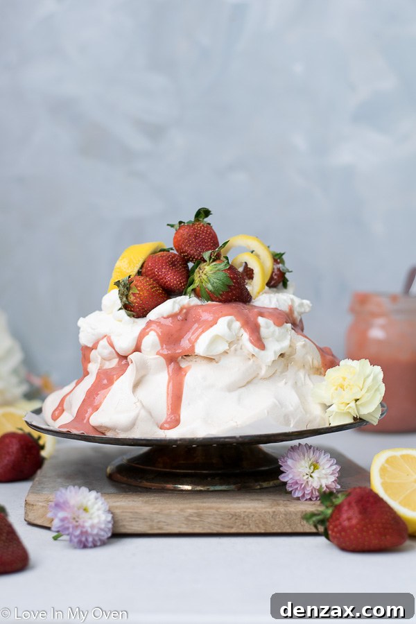 Fluffy and light strawberry lemon curd pavlova, topped with whipped cream and fresh strawberries