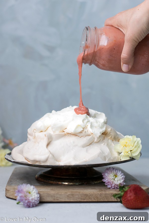 Fully assembled strawberry lemon curd pavlova, topped with whipped cream and fruit