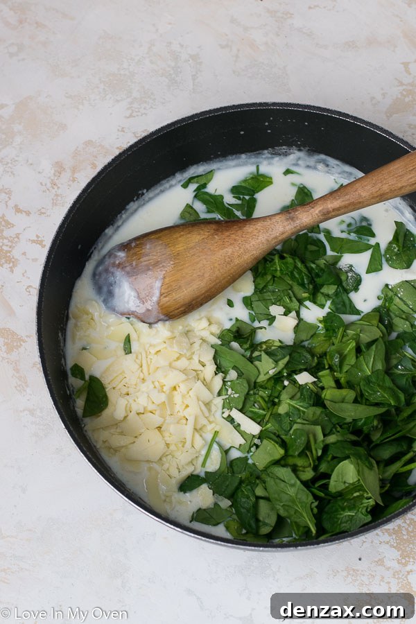 Finished creamy spinach gnocchi being stirred in a pan, ready to be served.