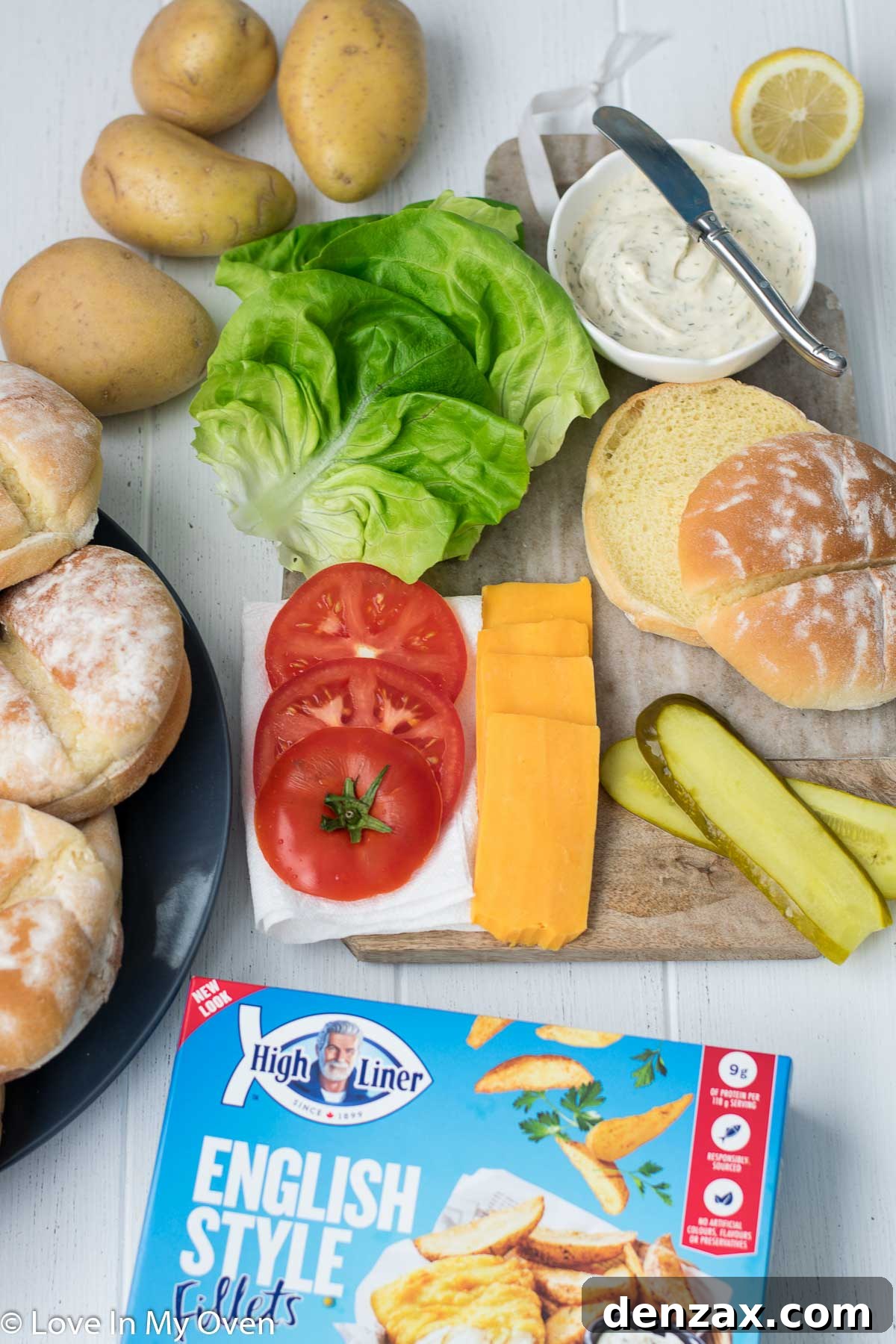 Freshly sliced tomatoes, pickles, lettuce, and cheese ready for burger assembly.