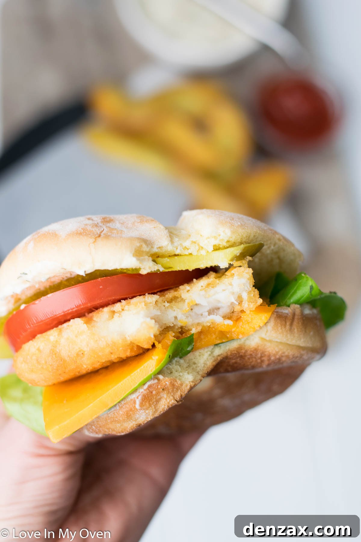 A perfectly assembled crispy fish burger with a generous dollop of lemon-garlic aioli.