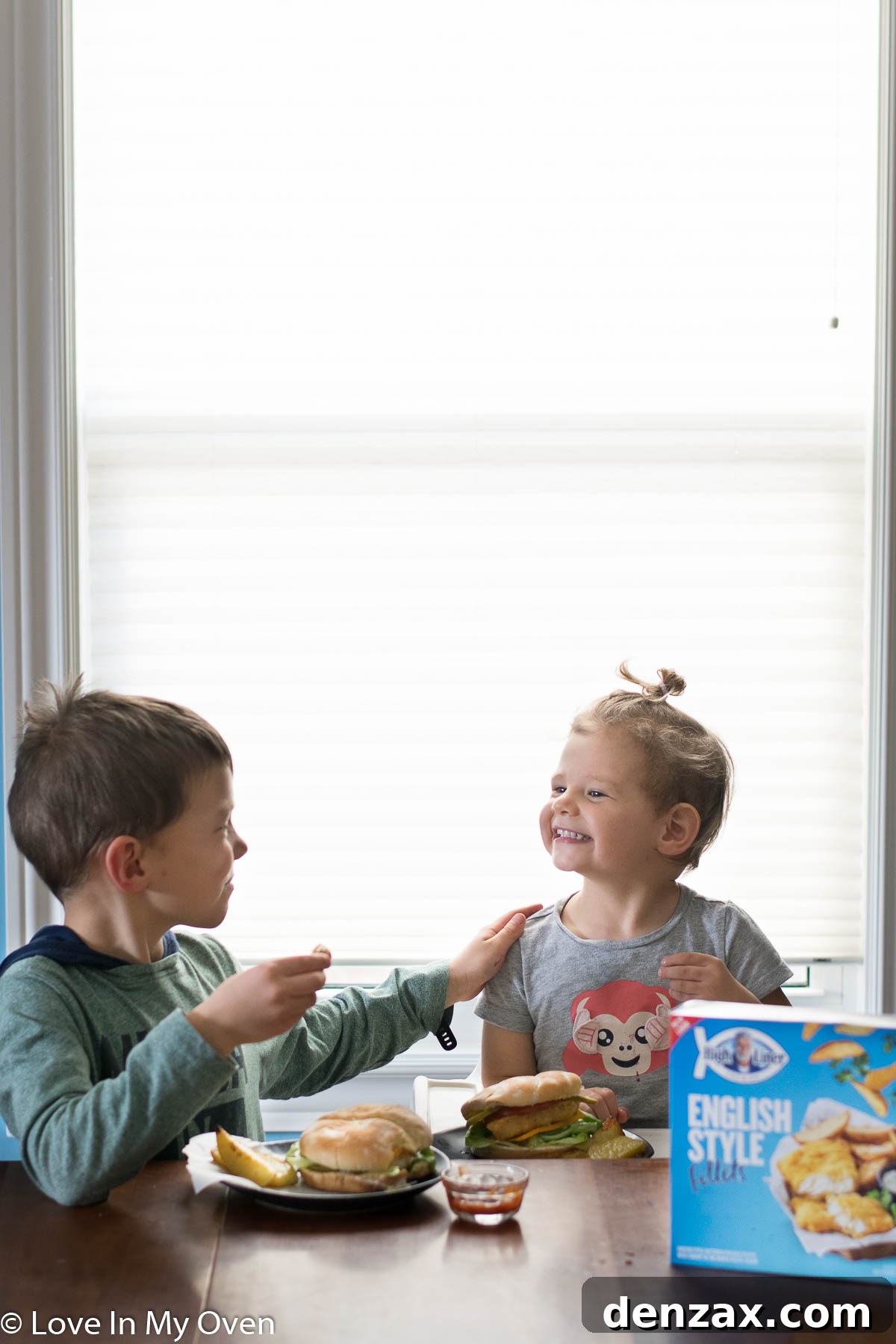 A family enjoying crispy fish burgers and potato wedges, showcasing a happy mealtime.