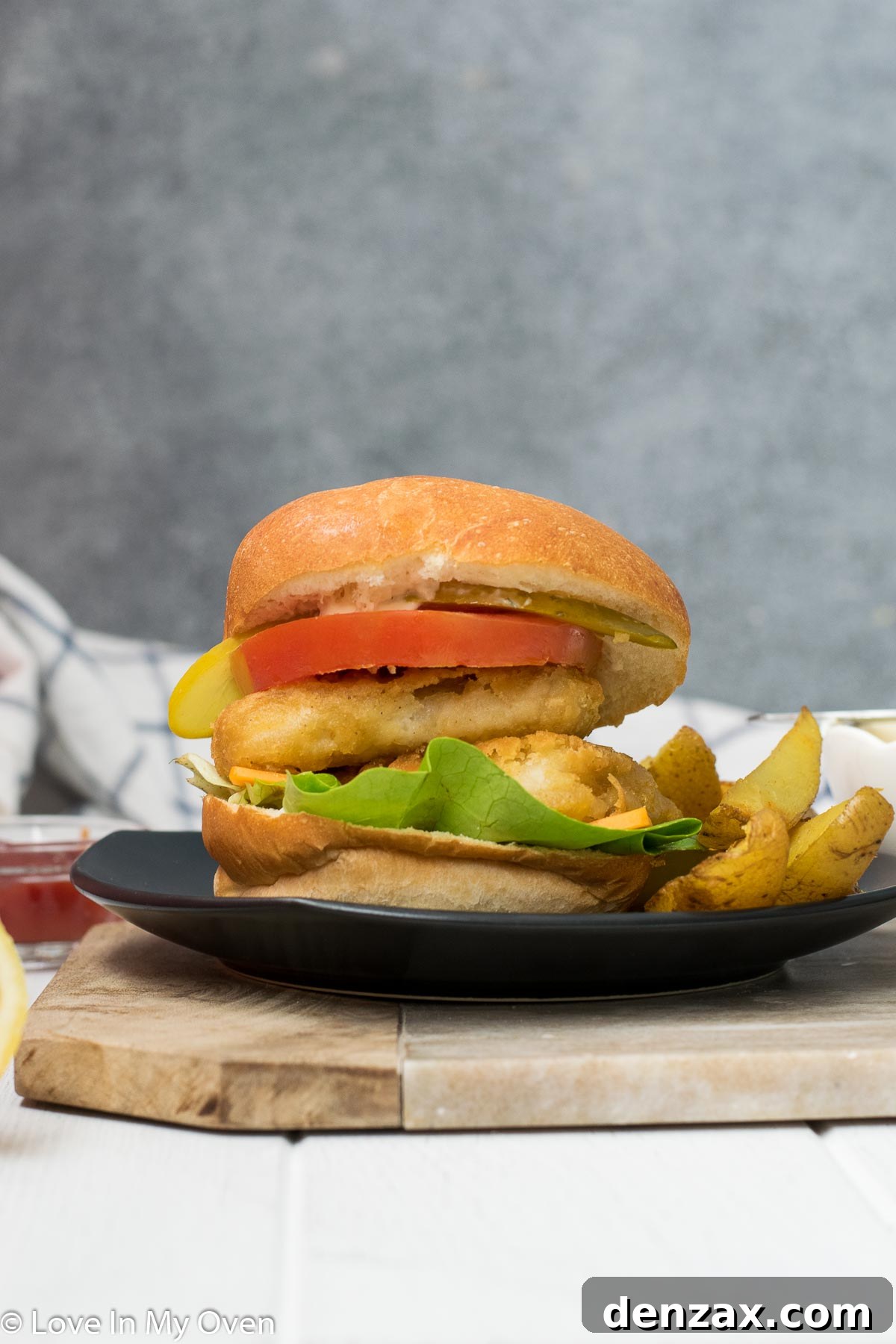 Several crispy fish burgers neatly arranged with golden potato wedges, ready to serve.