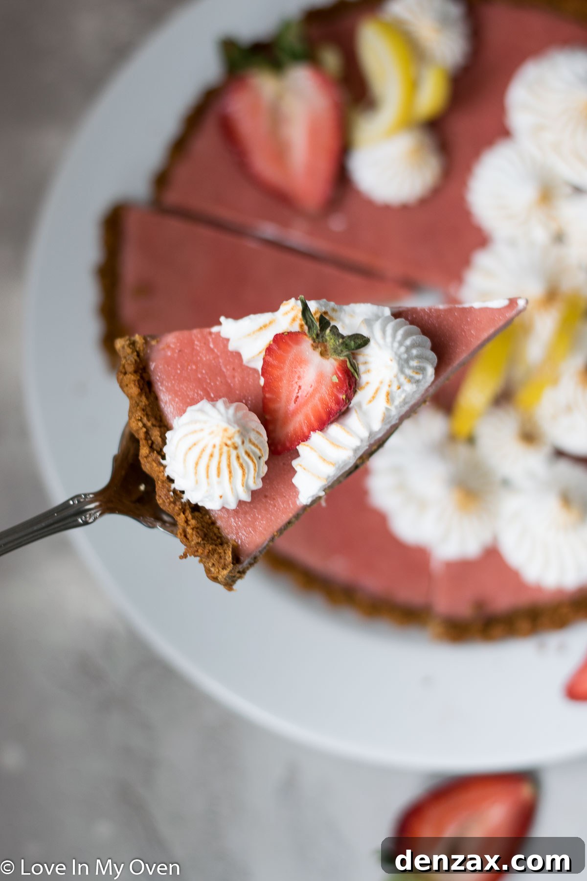 A perfectly sliced piece of strawberry lemon curd tart, showing the layers of crust, curd, and meringue.