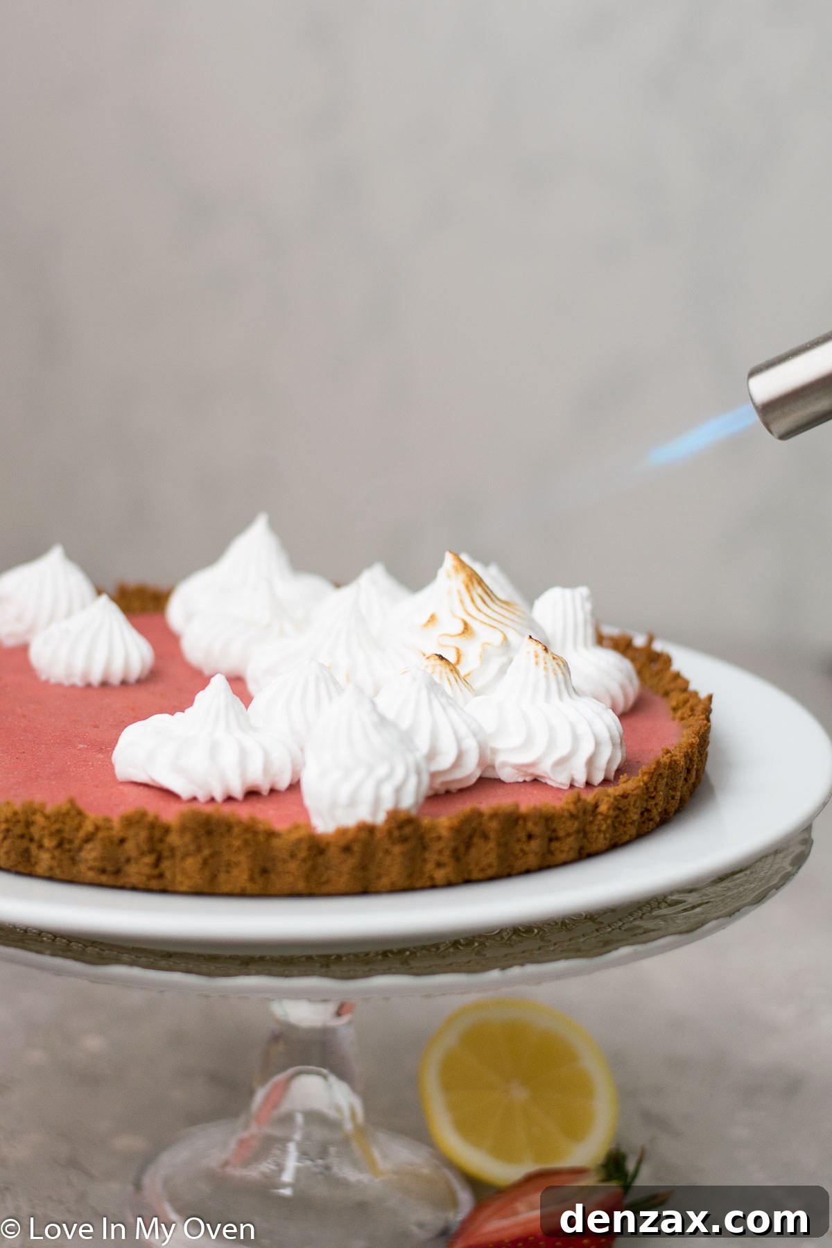 A beautifully decorated strawberry lemon curd tart with toasted meringue peaks.
