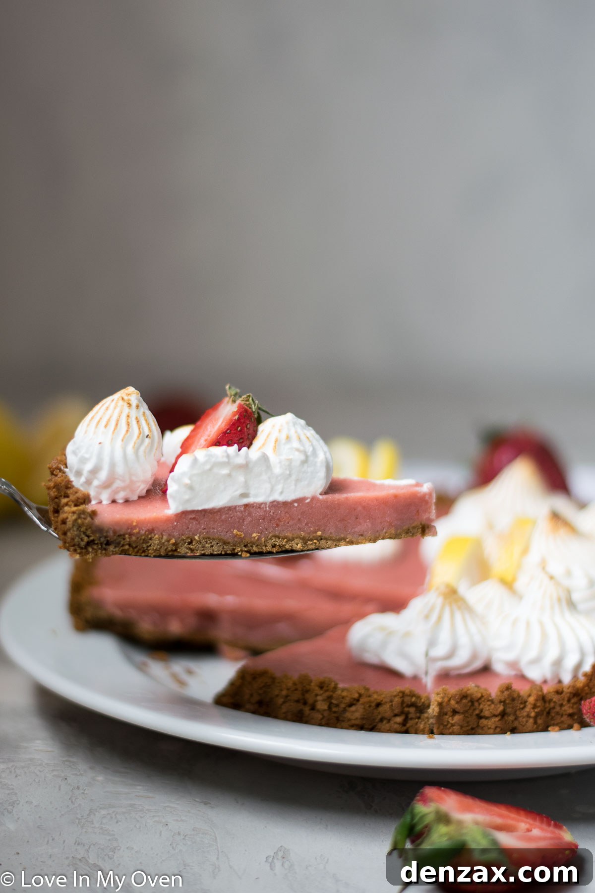 An overhead shot of a strawberry lemon curd tart, with a few fresh strawberries scattered around.
