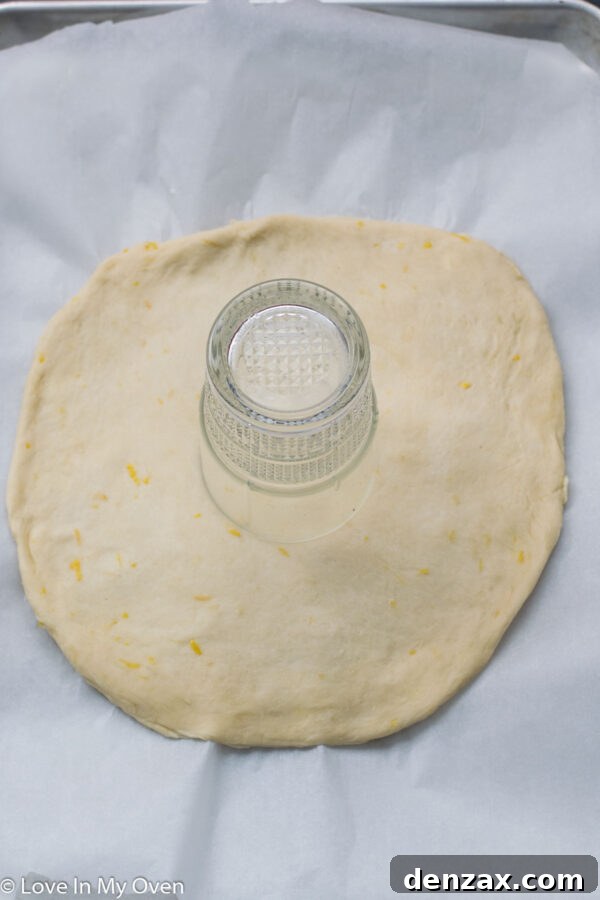 A small glass used to create a central indentation on the layered star bread dough.