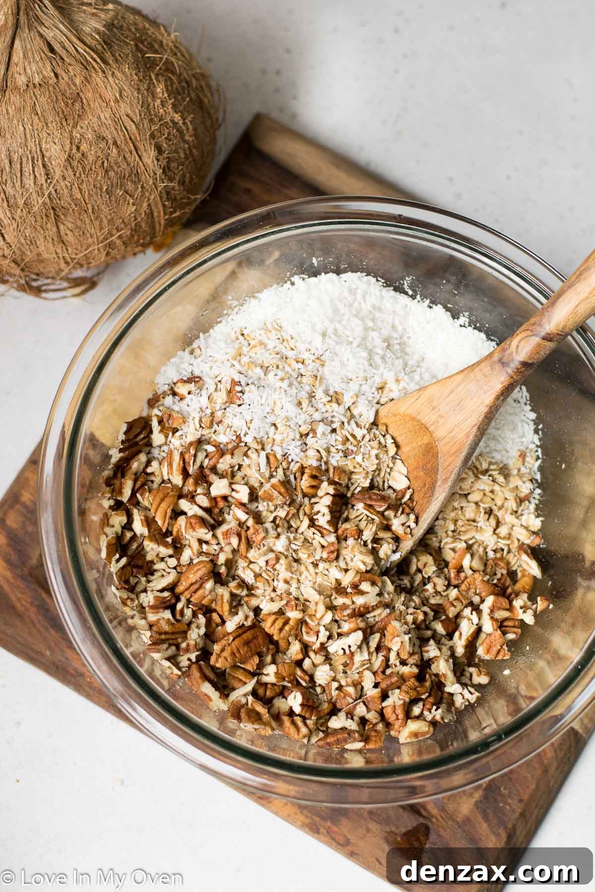 Homemade tropical granola mixture spread on a baking sheet before baking