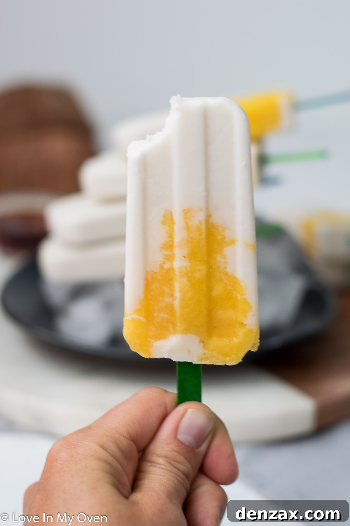 Stack of mango coconut popsicles in a bowl