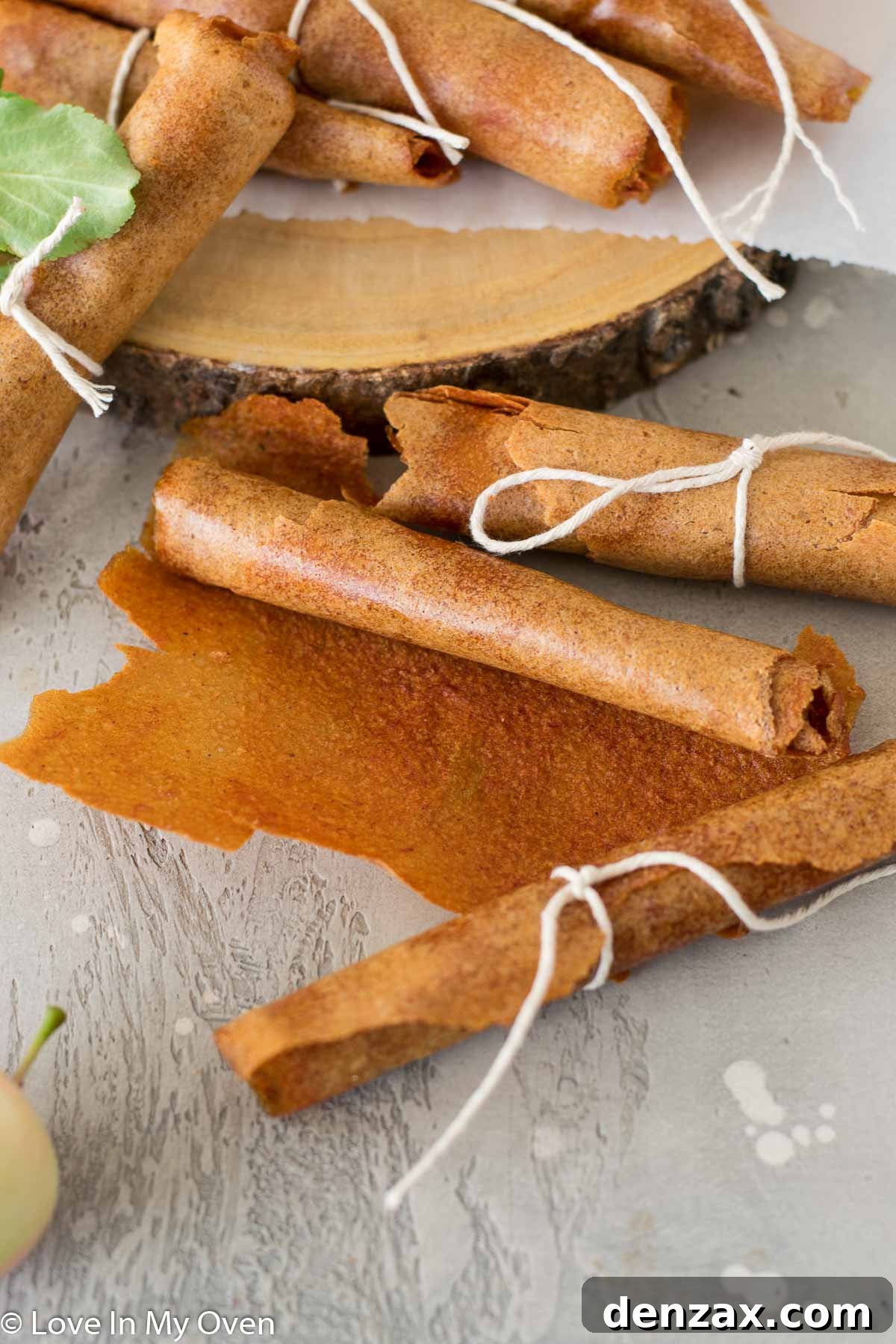 A child's hand holding a piece of homemade apple fruit leather, highlighting its flexibility
