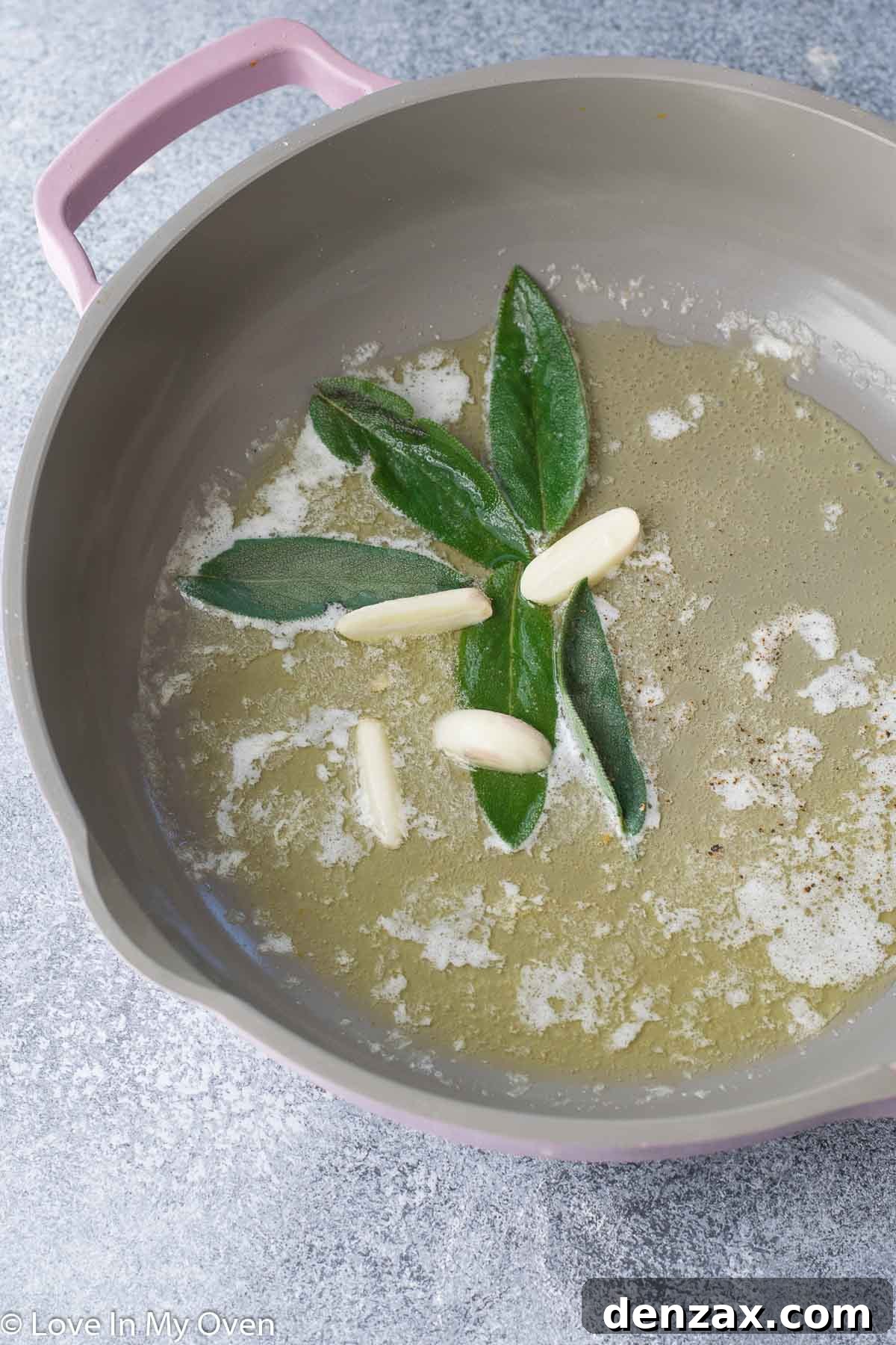 Fresh sage leaves sizzling in melted butter with garlic cloves