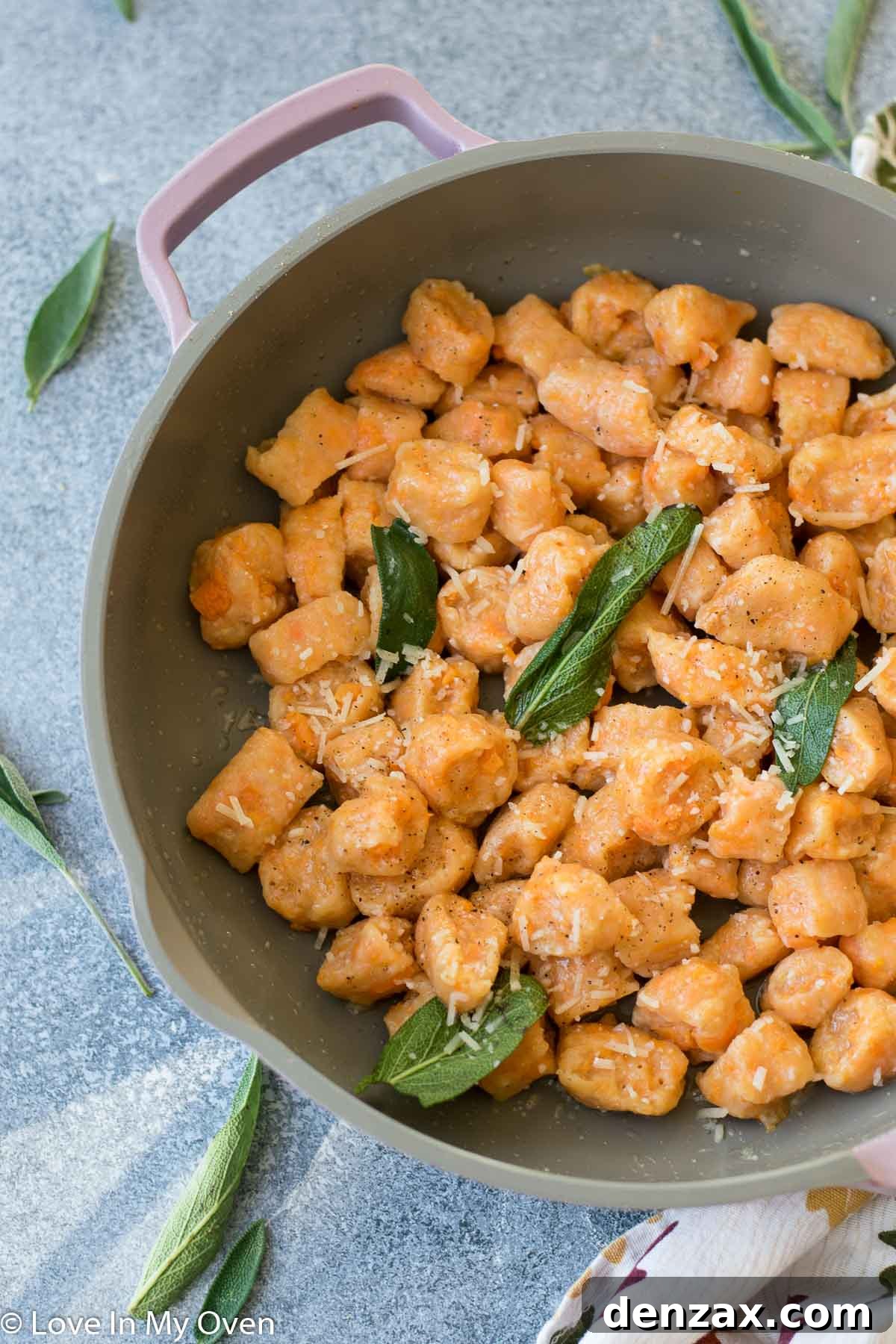 Plated sweet potato gnocchi garnished with fresh parmesan and pepper