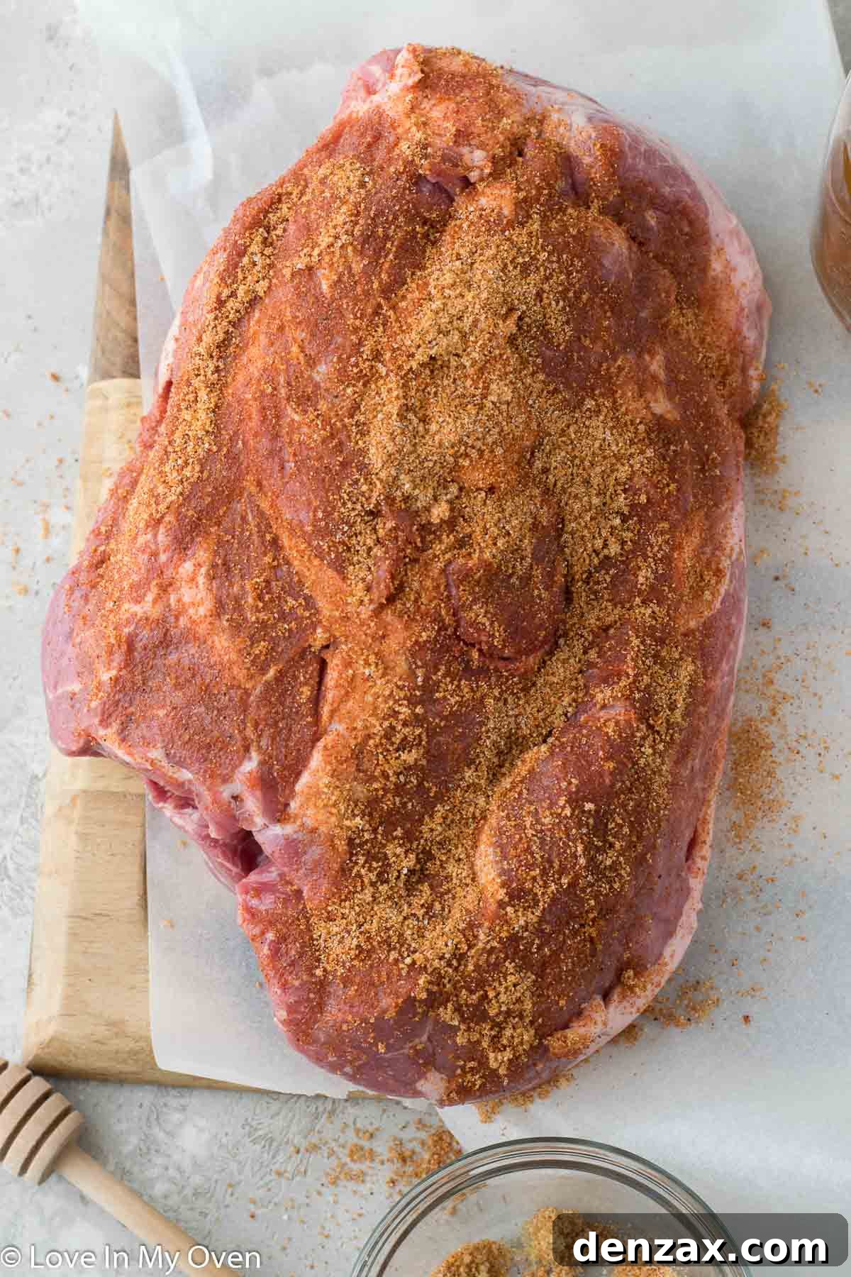 A seasoned pork shoulder covered in a spice rub, ready for the slow cooker.