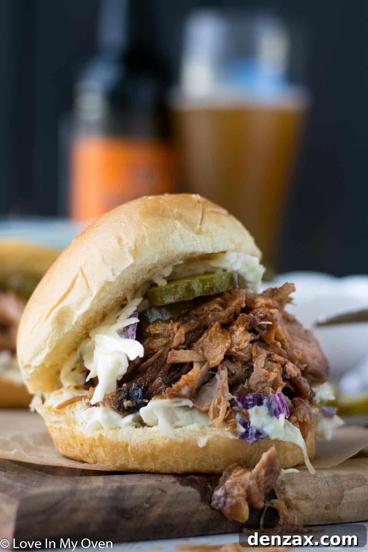 A fork pulling apart tender strands of apple cider pulled pork.