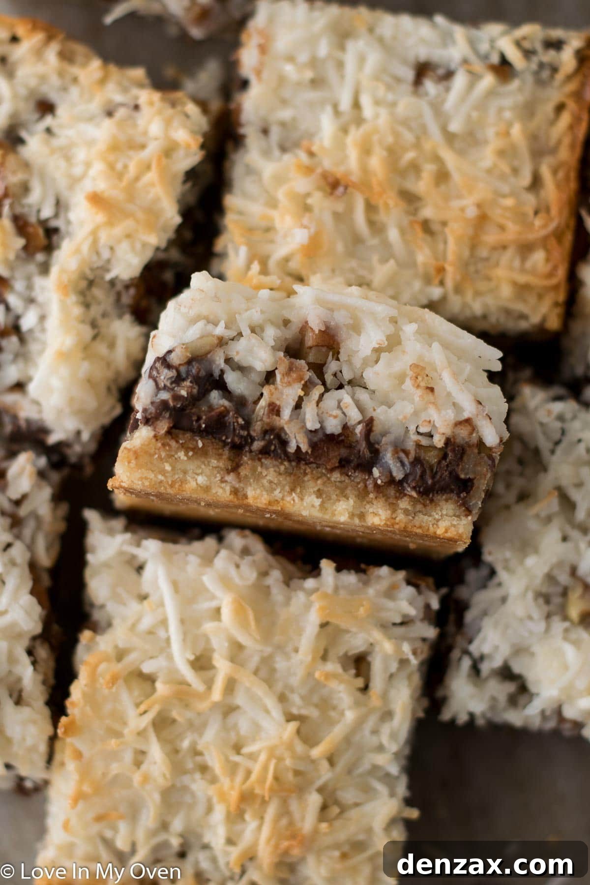 Close-up of the gooey, rich layers of vegan magic bars fresh from the oven, showing melted chocolate and toasted coconut.