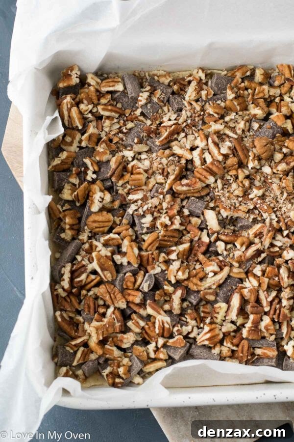 Another angle of the layered vegan magic bars, showcasing the abundance of pecans and chocolate.