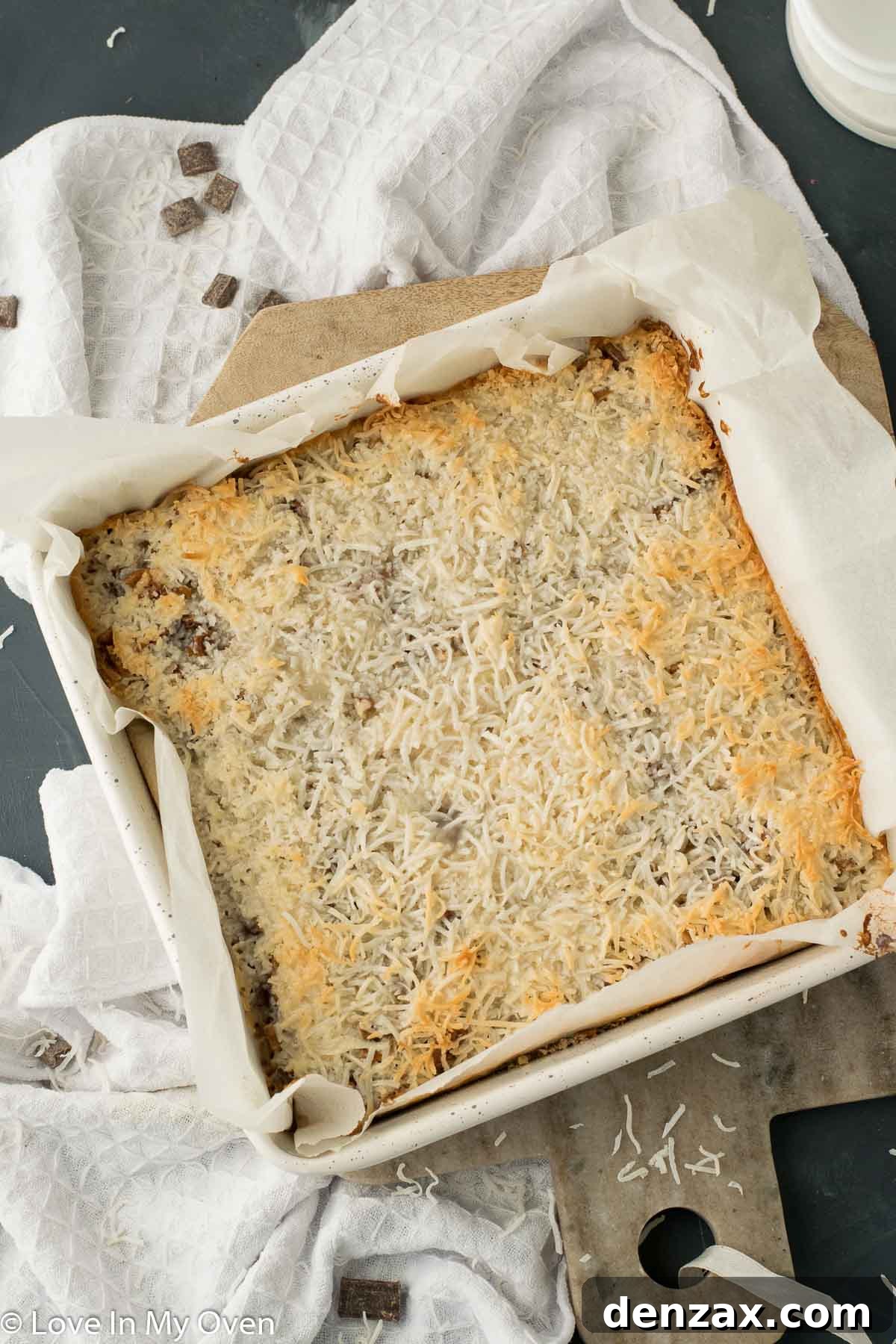 Freshly baked vegan magic bars, cooled and ready for chilling, showing their golden top and enticing layers.