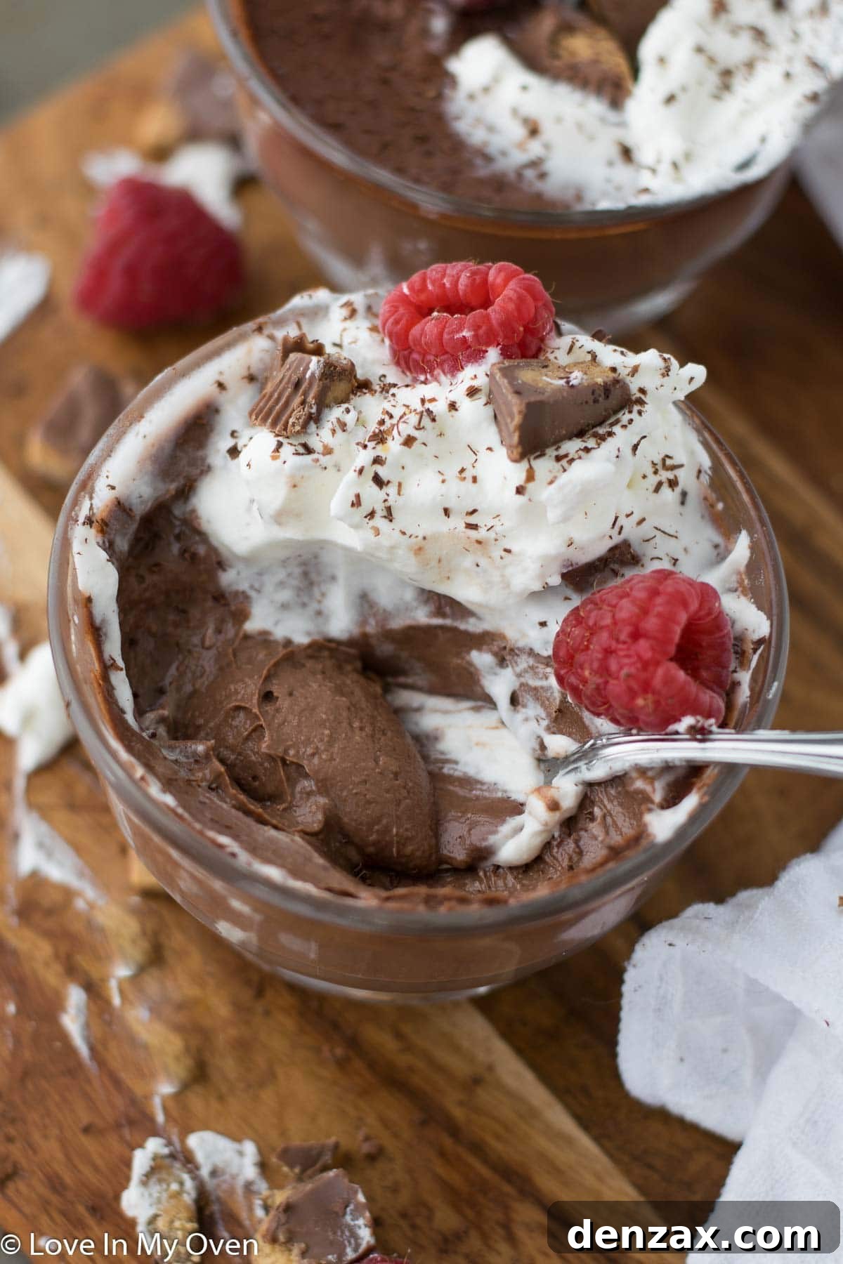 Close-up of a serving of vegan chocolate peanut butter pudding topped with whipped cream and chocolate shavings.