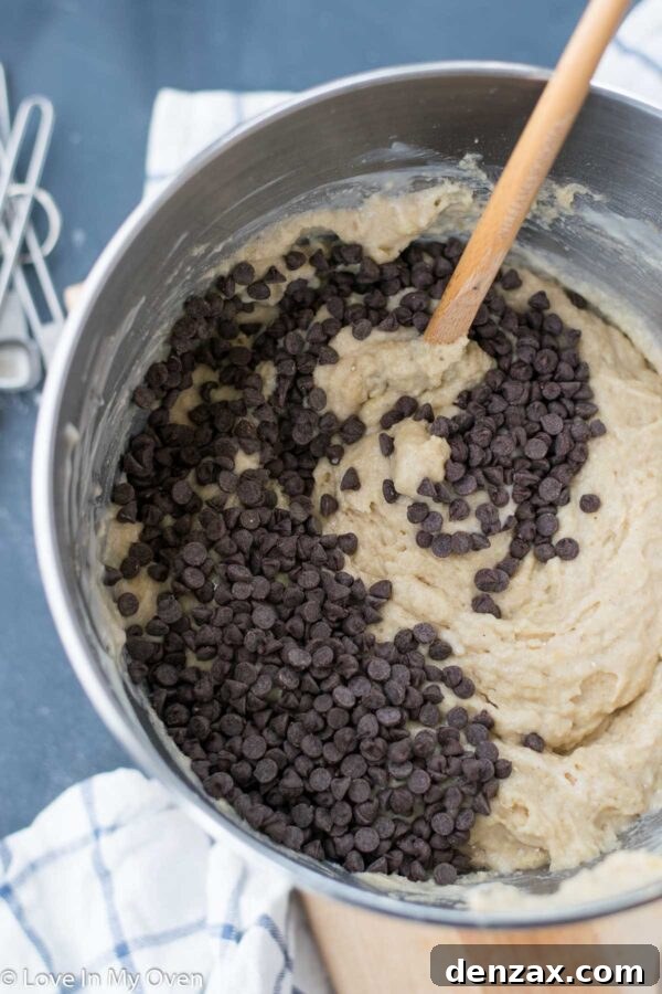 Banana cake batter being poured into a parchment-lined baking pan