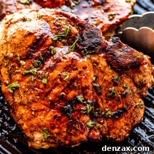 Tongs turning over grilled pork chops, showcasing a perfect char and juicy texture.