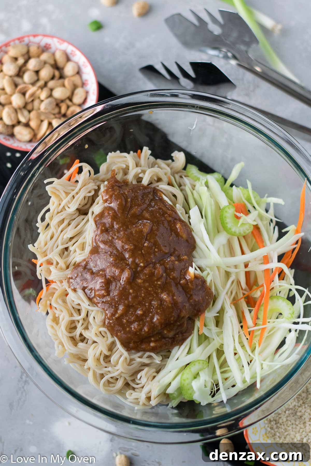 Mixing Sesame Peanut Noodle Salad in a large bowl