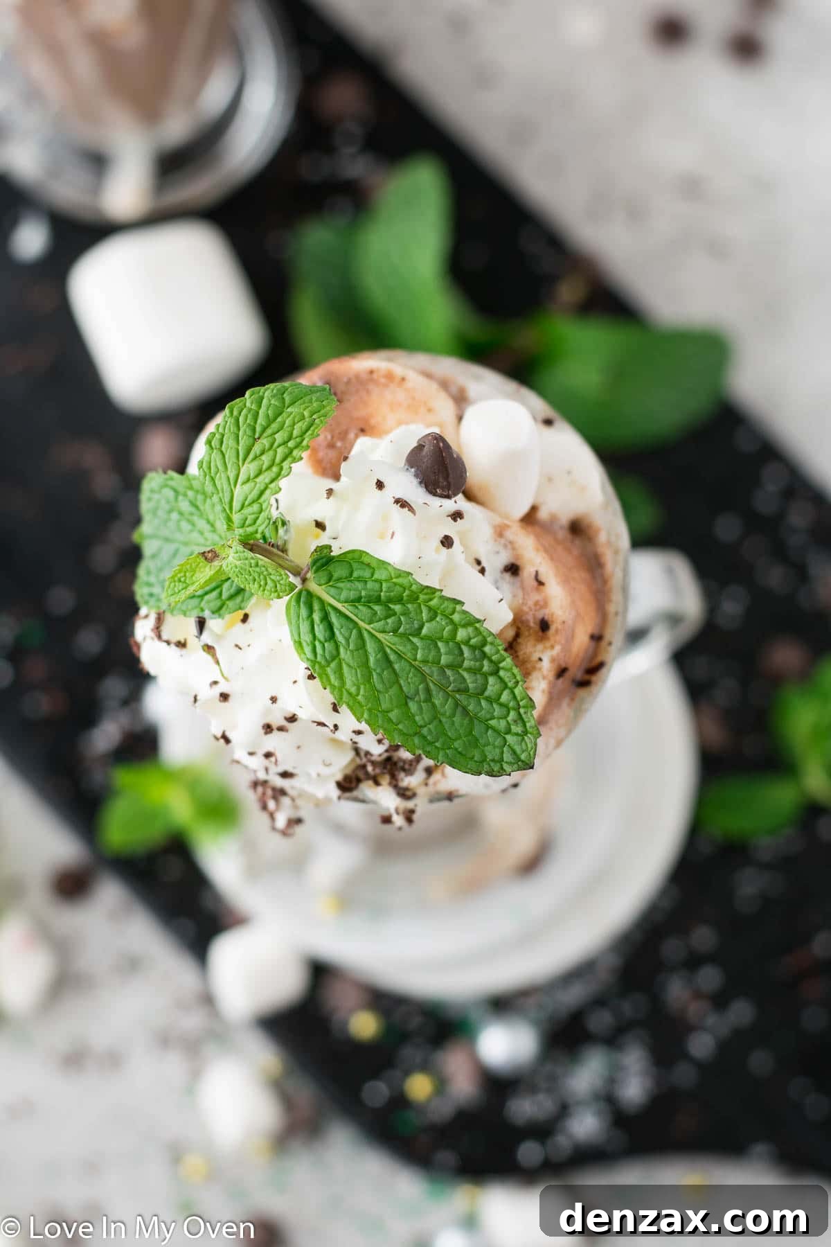 Close-up of a mint hot chocolate mug with whipped cream and chocolate shavings.