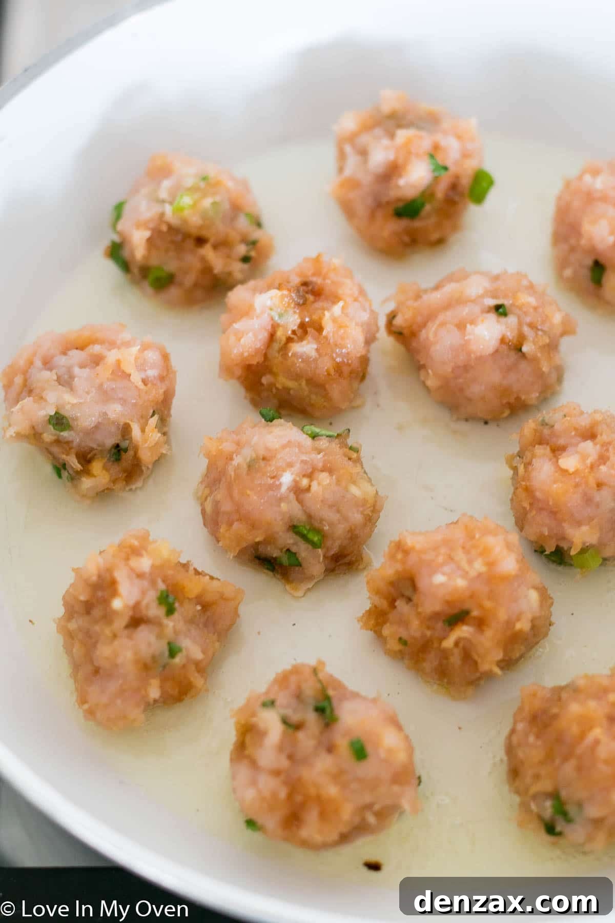 chicken meatballs cooking in pan