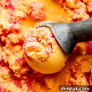 Close-up shot of mango strawberry frozen yogurt in an ice cream scoop
