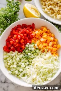 A bowl of macaroni salad ingredients, ready to be combined, showcasing the individual components before mixing.