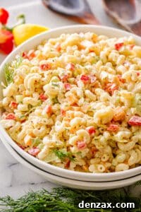A bowl of freshly mixed macaroni salad, with the dressing and vegetables thoroughly combined, before chilling.