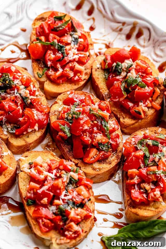 A white platter showcasing several slices of garlic bread bruschetta, each perfectly topped with a rich tomato and balsamic glaze mixture, highlighting its appetizing presentation.