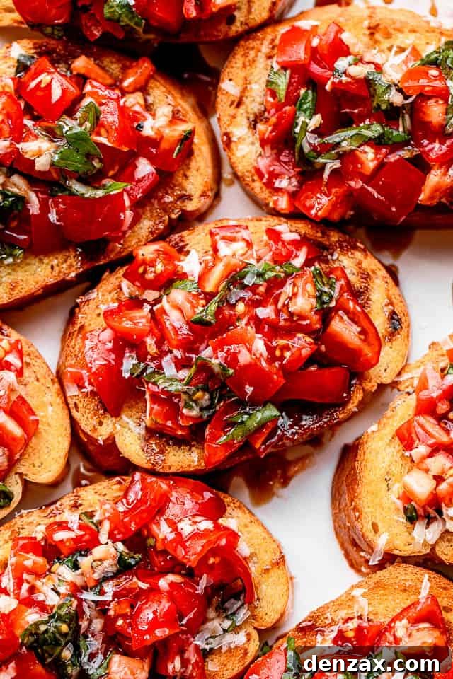 A close-up photograph showcasing the intricate details of a single garlic bread bruschetta piece, highlighting the fresh, diced tomatoes, basil, and the perfect toast of the bread.