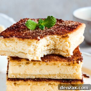 Three squares of sopapilla cheesecake stacked on a plate. One has had a bite taken from it.