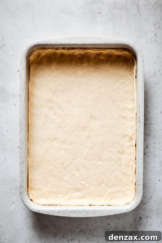 A baking dish lined with crescent roll dough.