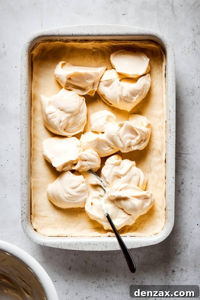 Cream cheese filling scooped into a baking dish.