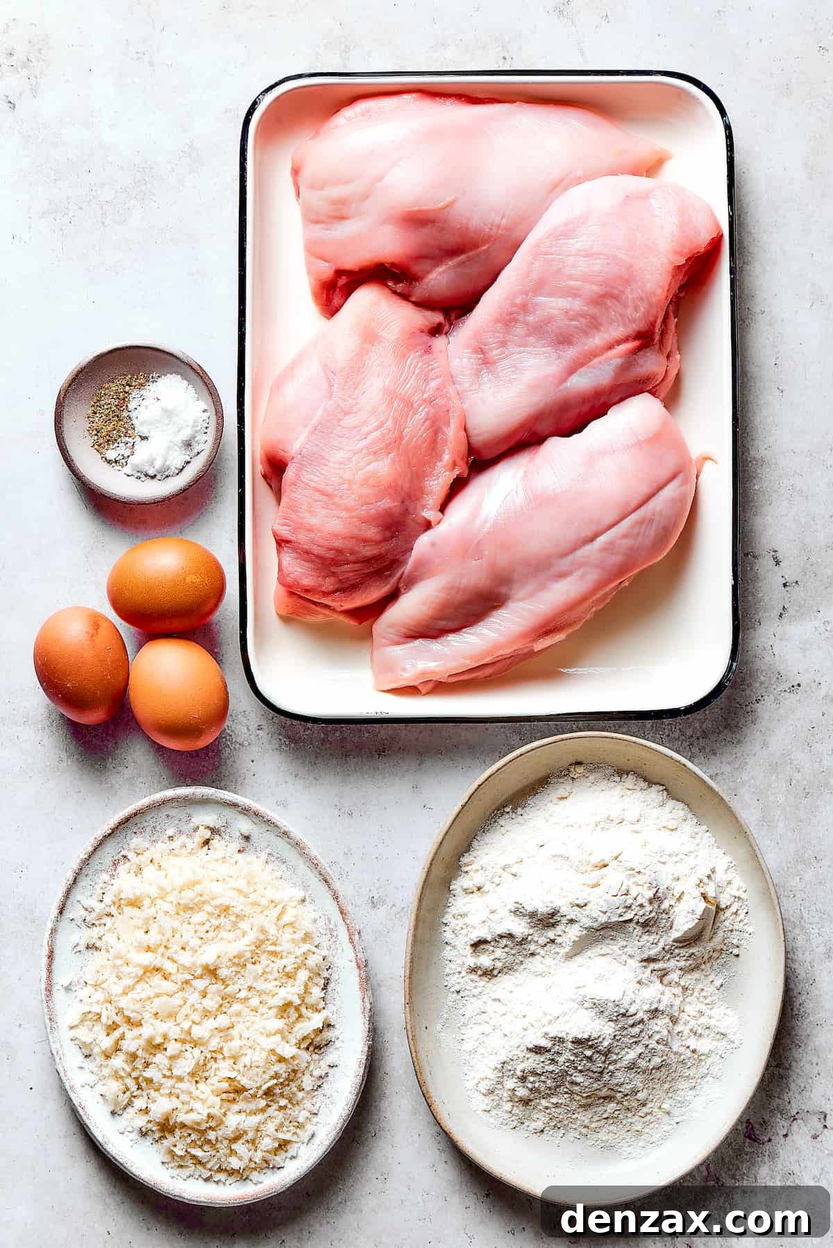 Main ingredients for breaded chicken: boneless skinless chicken breasts, flour, eggs, breadcrumbs, and seasonings.