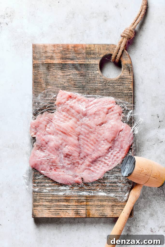 Chicken breast pounded thin between sheets of plastic wrap for even thickness.