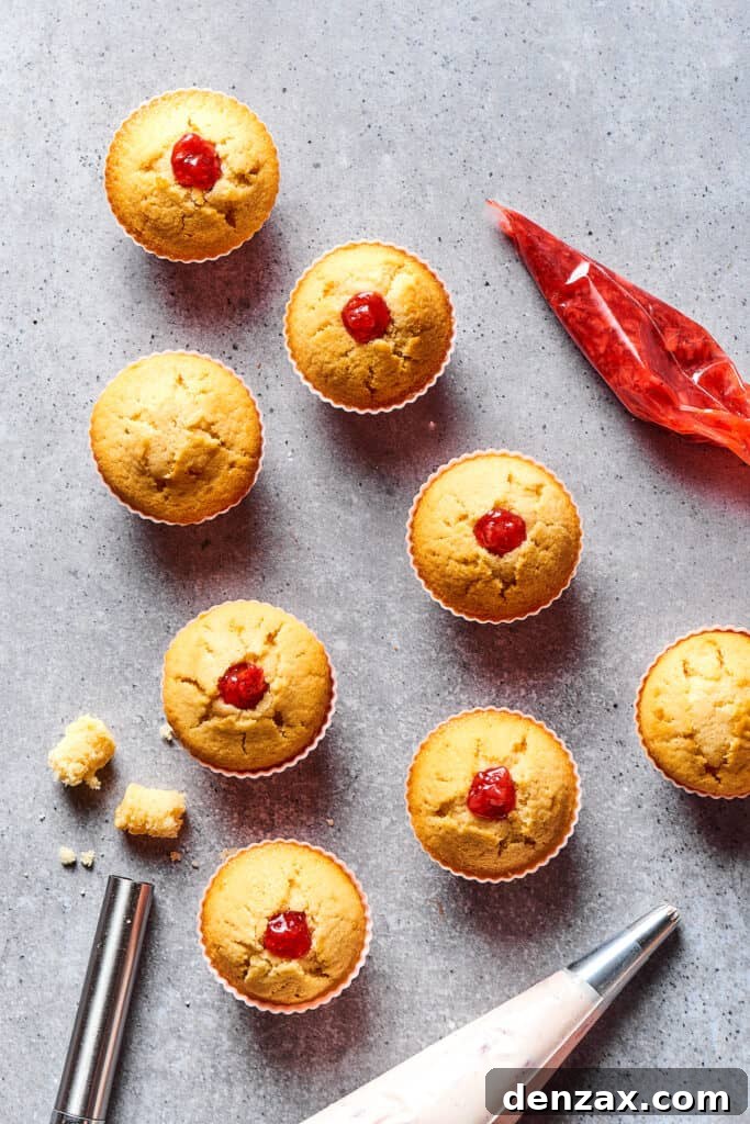 Cupcakes that have been cored and stuffed with delicious strawberry filling, ready for frosting.