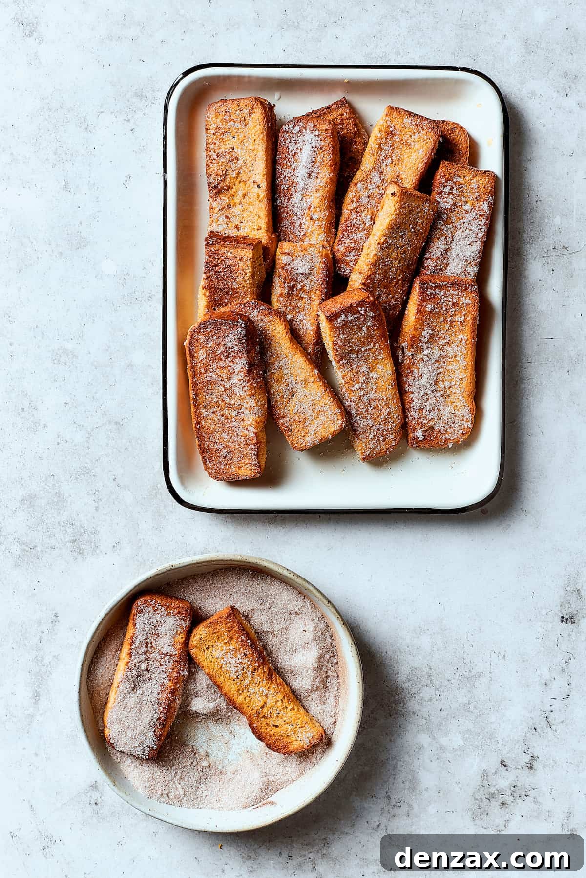 Rolling French toast sticks in cinnamon sugar.