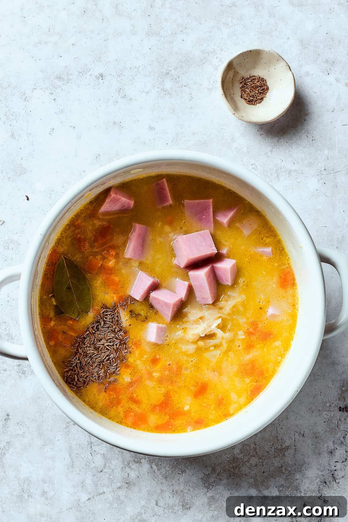 Reuben soup base simmering in a pot, rich with corned beef and sauerkraut, before adding dairy.