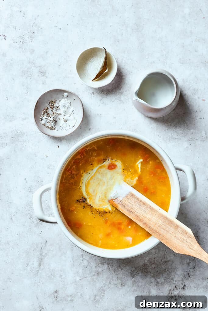 Stirring half-and-half into the finished soup to achieve a creamy consistency.