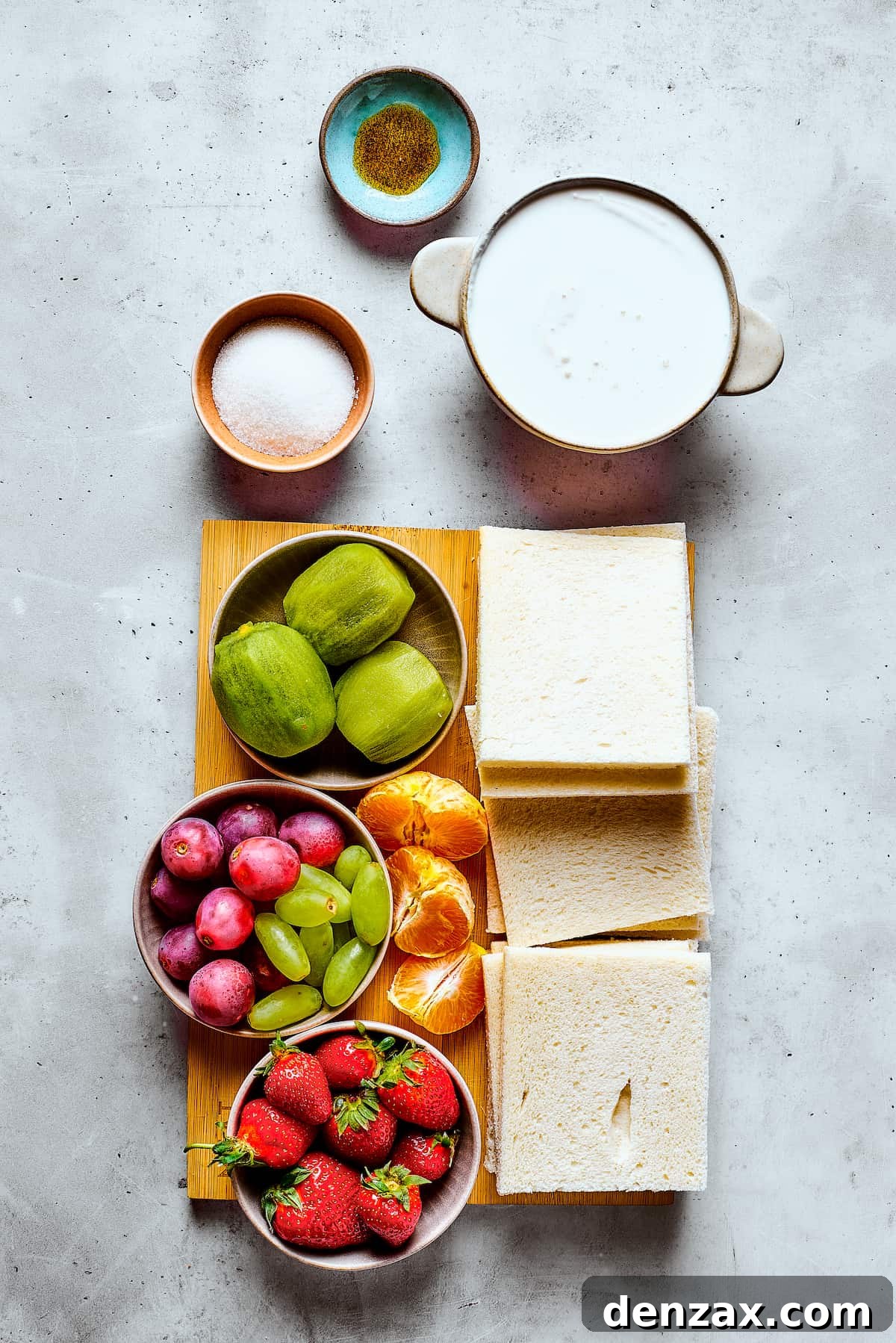 Ingredients for homemade fruit sando measured and arranged on a work surface, including bread, cream, sugar, vanilla, and various fresh fruits.