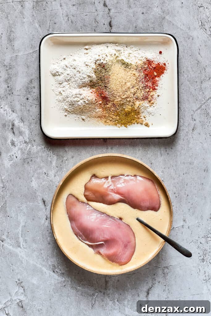 Soaking chicken breasts in a mixture of eggs and buttermilk for marination.