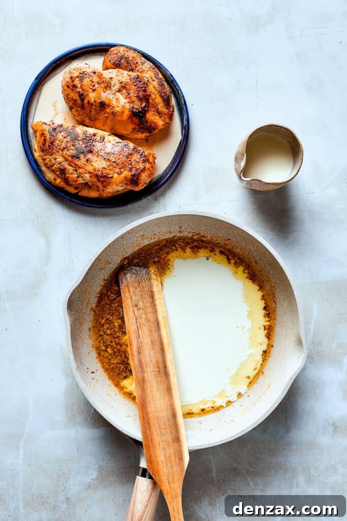 A wooden spoon stirring a creamy, bubbling sauce in a skillet, perfecting its consistency.